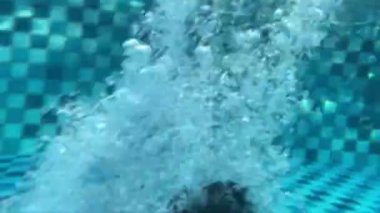 Havuza atlayan bir çocuk, 8 yaşındaki çocuklar için yaz tatili eğlencesi. Su sporları ve sağlıklı yaşam ile açık havada aktif yaşam tarzı