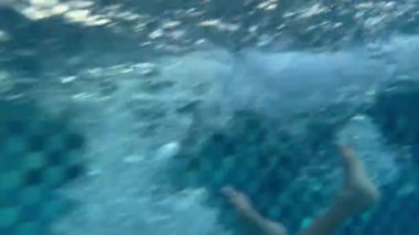 Havuza atlayan bir çocuk, 8 yaşındaki çocuklar için yaz tatili eğlencesi. Su sporları ve sağlıklı yaşam ile açık havada aktif yaşam tarzı