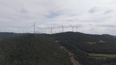 Yenilenebilir enerji kavramı. Arka planda gökyüzü ile dönen rüzgar türbinleri. 