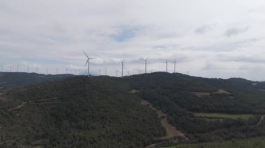 Yenilenebilir enerji kavramı. Arka planda gökyüzü ile dönen rüzgar türbinleri. 