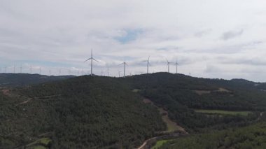Yenilenebilir enerji kavramı. Arka planda gökyüzü ile dönen rüzgar türbinleri. 