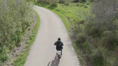 Sıcak ve güneşli bir günde bisiklet süren bir adam.