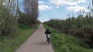 Sıcak ve güneşli bir günde bisiklet süren bir adam.