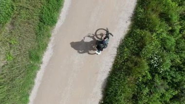 Sıcak ve güneşli bir günde bisikletli bir adam ve akıllı bir telefon.