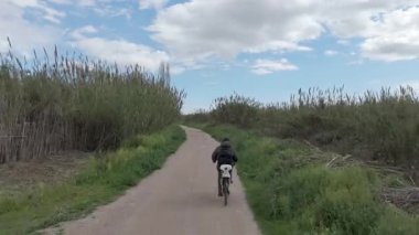 Sıcak ve güneşli bir günde bisiklet süren bir adam.