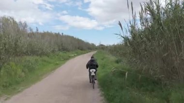 Sıcak ve güneşli bir günde bisiklet süren bir adam.