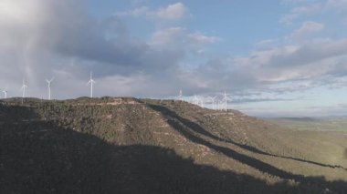 Rüzgar türbinleri arka planda günbatımı gökyüzü ile dönüyor. yenilenebilir enerji kavramı 