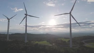 Rüzgar türbinleri arka planda günbatımı gökyüzü ile dönüyor. yenilenebilir enerji kavramı 