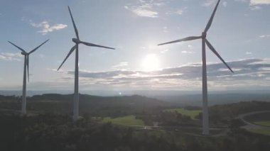Rüzgar türbinleri arka planda günbatımı gökyüzü ile dönüyor. yenilenebilir enerji kavramı 