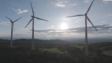 Rüzgar türbinleri arka planda günbatımı gökyüzü ile dönüyor. yenilenebilir enerji kavramı 