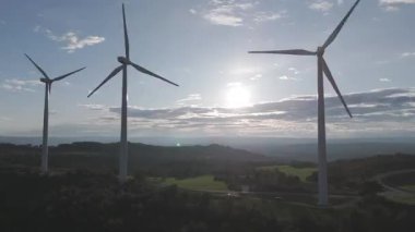 Rüzgar türbinleri arka planda günbatımı gökyüzü ile dönüyor. yenilenebilir enerji kavramı 