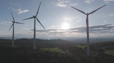 Rüzgar türbinleri arka planda günbatımı gökyüzü ile dönüyor. yenilenebilir enerji kavramı 