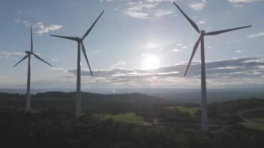 Rüzgar türbinleri arka planda günbatımı gökyüzü ile dönüyor. yenilenebilir enerji kavramı 