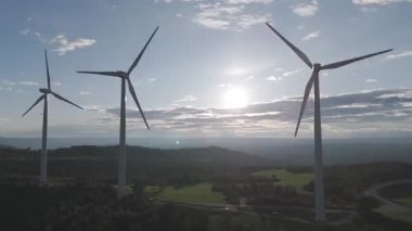 Rüzgar türbinleri arka planda günbatımı gökyüzü ile dönüyor. yenilenebilir enerji kavramı 