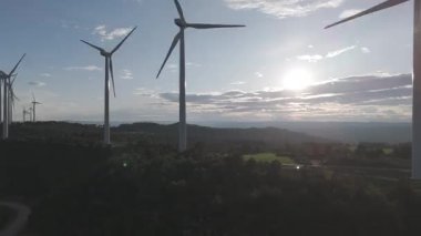 Rüzgar türbinleri arka planda günbatımı gökyüzü ile dönüyor. yenilenebilir enerji kavramı 
