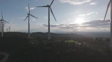 Rüzgar türbinleri arka planda günbatımı gökyüzü ile dönüyor. yenilenebilir enerji kavramı 