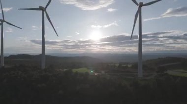 Rüzgar türbinleri arka planda günbatımı gökyüzü ile dönüyor. yenilenebilir enerji kavramı 