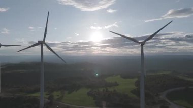 Rüzgar türbinleri arka planda günbatımı gökyüzü ile dönüyor. yenilenebilir enerji kavramı 