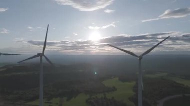 Rüzgar türbinleri arka planda günbatımı gökyüzü ile dönüyor. yenilenebilir enerji kavramı 
