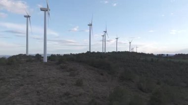 Rüzgar türbinleri arka planda günbatımı gökyüzü ile dönüyor 