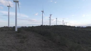 Rüzgar türbinleri arka planda günbatımı gökyüzü ile dönüyor 