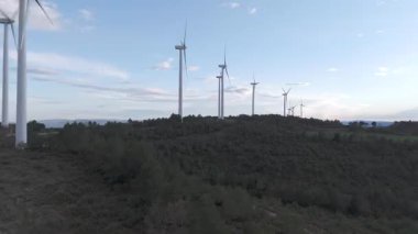 Rüzgar türbinleri arka planda günbatımı gökyüzü ile dönüyor 