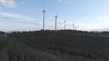 Rüzgar türbinleri arka planda günbatımı gökyüzü ile dönüyor 