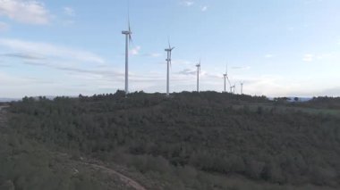 Rüzgar türbinleri arka planda günbatımı gökyüzü ile dönüyor 