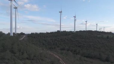 Rüzgar türbinleri arka planda günbatımı gökyüzü ile dönüyor 