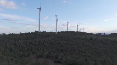 Rüzgar türbinleri arka planda günbatımı gökyüzü ile dönüyor 