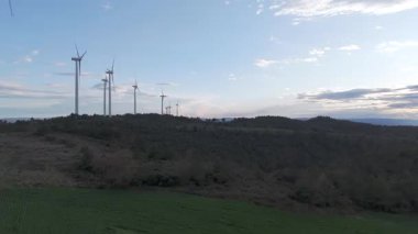 Rüzgar türbinleri arka planda günbatımı gökyüzü ile dönüyor 