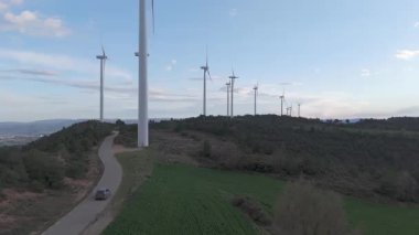 Rüzgar türbinleri arka planda günbatımı gökyüzü ile dönüyor. yenilenebilir enerji kavramı 