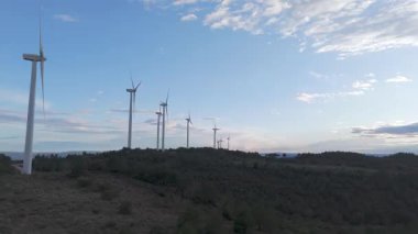 Rüzgar türbinleri arka planda günbatımı gökyüzü ile dönüyor. yenilenebilir enerji kavramı 