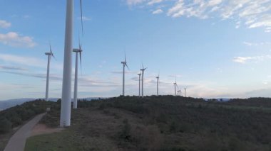 Rüzgar türbinleri arka planda günbatımı gökyüzü ile dönüyor. yenilenebilir enerji kavramı 