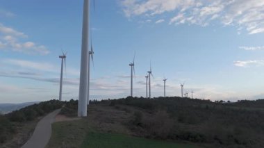 Rüzgar türbinleri arka planda günbatımı gökyüzü ile dönüyor. yenilenebilir enerji kavramı 