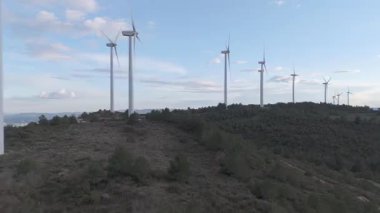 Yenilenebilir enerji kavramı. Arka planda gökyüzü ile dönen rüzgar türbinleri. 