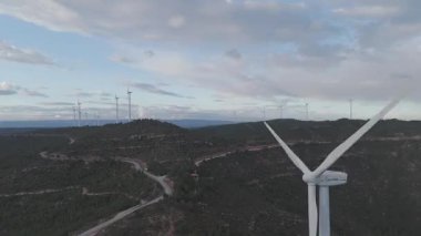 Yenilenebilir enerji kavramı. Arka planda gökyüzü ile dönen rüzgar türbinleri. 
