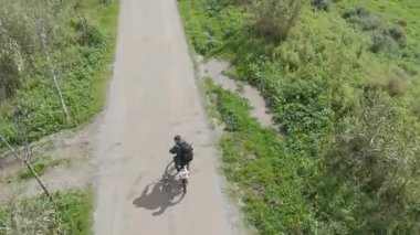 Sıcak ve güneşli bir günde bisiklet süren bir adam.