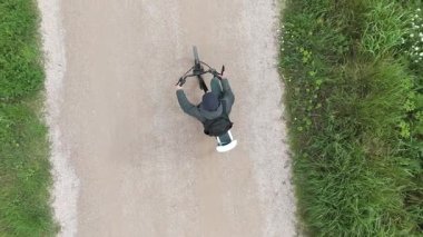 Genç adam güneşli bir günde bisiklet sürüyor.