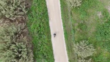 Akıllı telefonlu bisikletli bir adam güneşli bir günde yol bulmaya çalışıyor.