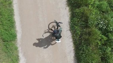 Akıllı telefonlu bisikletli bir adam güneşli bir günde yol bulmaya çalışıyor.