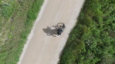 Akıllı telefonlu bisikletli bir adam güneşli bir günde yol bulmaya çalışıyor.