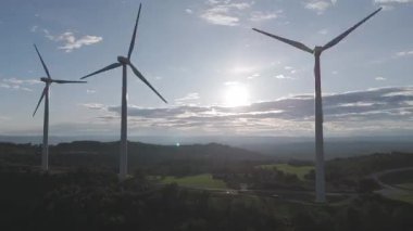 Yenilenebilir enerji kavramı. Günbatımında rüzgar gülleri