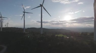Yenilenebilir enerji kavramı. Günbatımında rüzgar gülleri