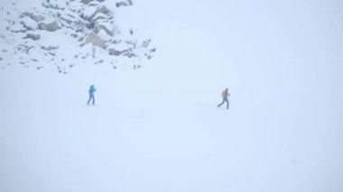 Kış mevsiminde dağların manzarası. İki kişi kayak yapıyor. 