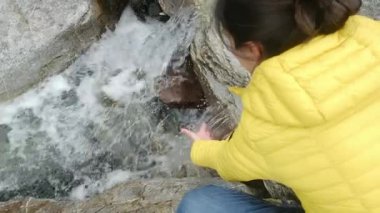 Elleri soğuk nehir buharlı suyunda yıkayan kadın videosu. Dağlarda kış mevsimi 