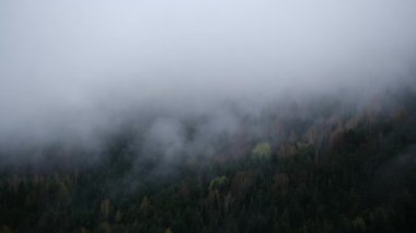 Bulutlu havada sisli dağların insansız hava aracı videosu.