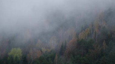 Bulutlu havada sisli dağların manzarasını gösteren drone videosu. Soğuk hava 