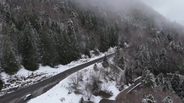 Aralarından bir yol geçen dağlar. Uçan bir dronun perspektifinden çekilen video.