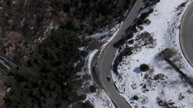 İHA videosu. Karlı güzel ormanın havadan manzarası ve arabalı yollar. 